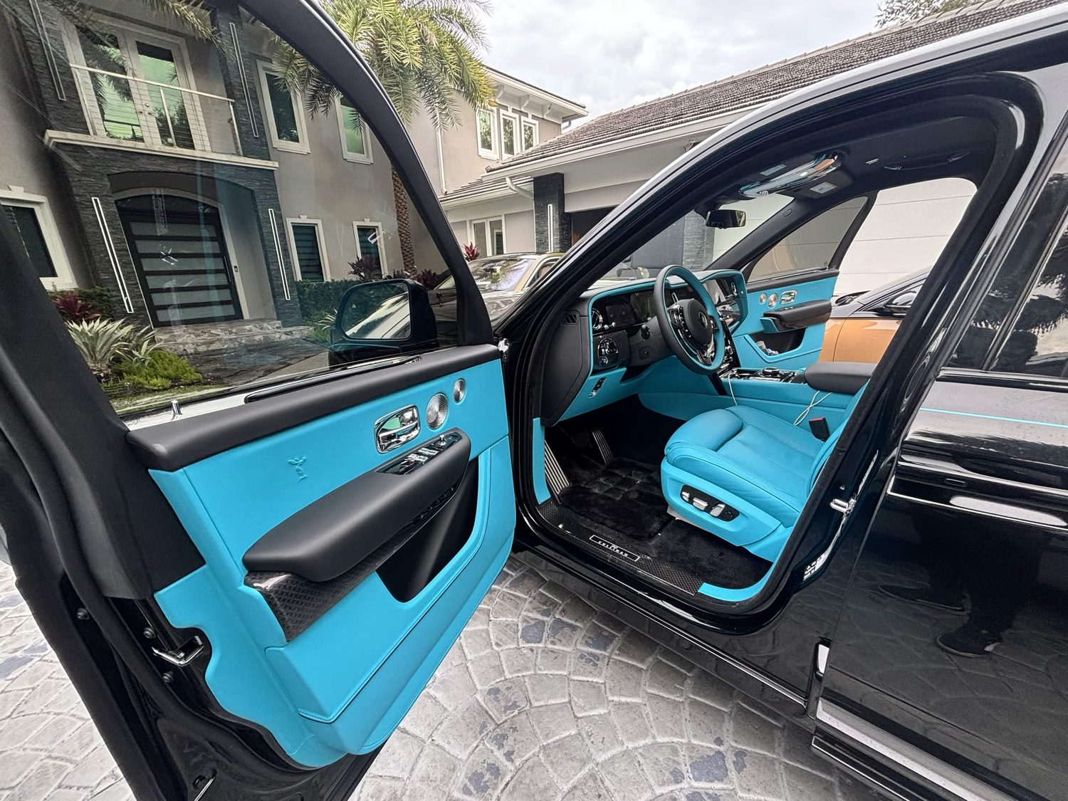 Black Cullinan front door open in a driveway
